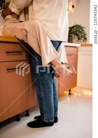 Romantic Couple Embracing in Warm Kitchen Setting Romantic Couple Embracing in Warm Kitchen Setting 129745842