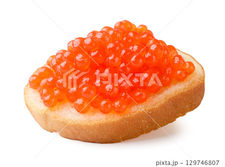 Red caviar on a piece of bread close-up on a white. Isolated Red caviar on a piece of bread close-up on a white. Isolated 129746807