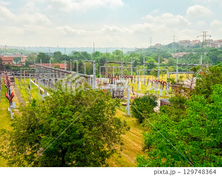 High-voltage power substation in a green landscape. Energy infrastructure, electricity distribution, and technology integration in modern urban planning. 129748364