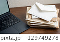 積み重なった封筒とノートパソコン 129749278