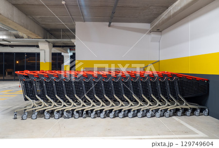 Many shopping carts are neatly arranged in an underground parking garage, ready for customers to use Many shopping carts are neatly arranged in an underground parking garage, ready for customers to use 129749604