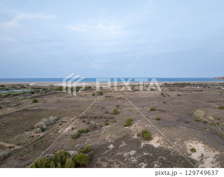 Aerial view of Leucate coastline showing dry vegetation and the Mediterranean sea in Occitanie, France Aerial view of Leucate coastline showing dry vegetation and the Mediterranean sea in Occitanie, France 129749637