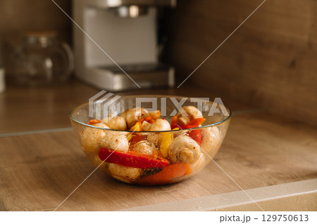 Colorful vegetable medley in a glass bowl on a kitchen countertop during meal preparation 129750613