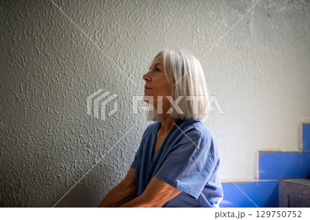 Exhausted nurse resting on stairwell during hospital shift Exhausted nurse resting on stairwell during hospital shift 129750752