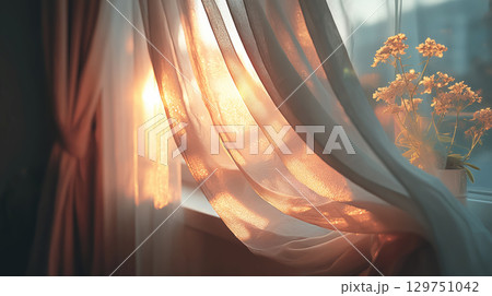 Soft sunlight shining through sheer curtains with flowers in the background 129751042