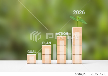 Business growth success achievement concept. Plan, goal and action to achieve success in 2026. Wooden blocks in form of graphical steps up and young green seedling of business growth process. 129751479