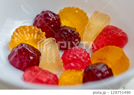 Assorted fruit jelly candies in various shapes and colors are displayed in close-up shot. The image captures the vibrant colors and textures of deliciously sweet treats Assorted fruit jelly candies in various shapes and colors are displayed in close-up shot. The image captures the vibrant colors and textures of deliciously sweet treats 129751490