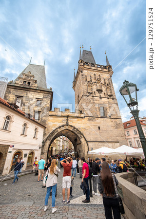 Prague, Czech Republic, August 6, 2023. Vertical shot of the entrance portal of Charles Bridge. A crowded tourist destination. Prague, Czech Republic, August 6, 2023. Vertical shot of the entrance portal of Charles Bridge. A crowded tourist destination. 129751524