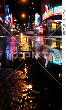 Empty neon-lit city street at night after rain 129752900
