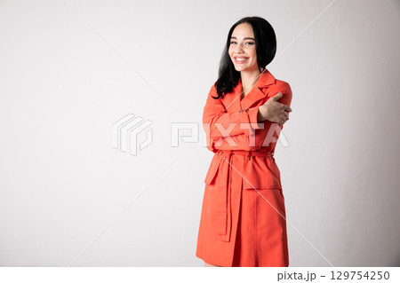 Portrait of a beautiful fashionable brunette woman in a red summer dress Portrait of a beautiful fashionable brunette woman in a red summer dress 129754250
