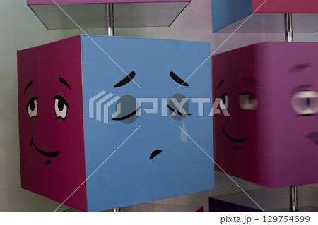 Colorful rotating cubes displaying various emotions, including sadness. Perfect for teaching children about emotional recognition, with focus on understanding feelings like sadness in interactive way 129754699