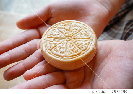 手のひらにのせた和菓子のみかん最中 繊細な和の甘味と伝統文化 129754902