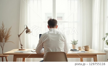 Person working in Scandinavian home office, back view Person working in Scandinavian home office, back view 129755116