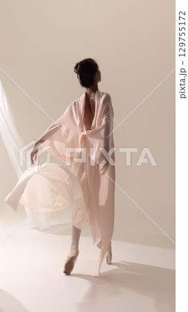 Dancer in flowing sheer robe moving gracefully on pointe Dancer in flowing sheer robe moving gracefully on pointe 129755172