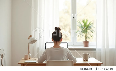 Person working in Scandinavian home office, back view 129755246