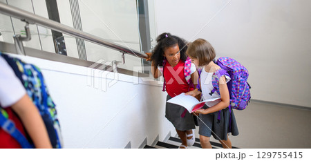 Girl friends talking in school hallway. Banner with copy space. Girl friends talking in school hallway. Banner with copy space. 129755415