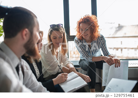 Team brainstorming in modern office, discussing marketing strategy. Team brainstorming in modern office, discussing marketing strategy. 129755461