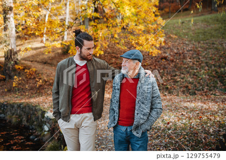 Senior father and his son walking in nature, talking. 129755479