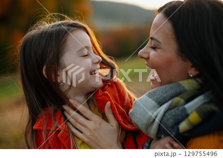 Young mother with a small daughter in autumn nature. 129755496