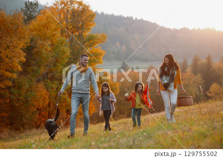 Happy young family with two children in autumn nature at sunset. 129755502