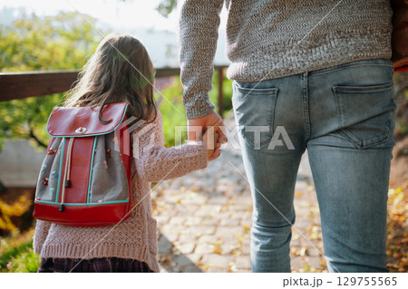 Parent walking child to school on first day, holding hands. Parent walking child to school on first day, holding hands. 129755565