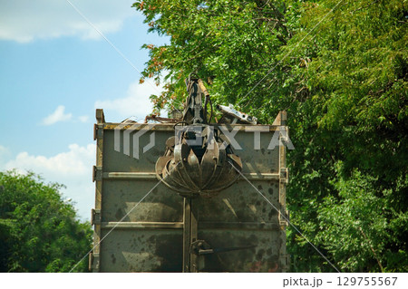 Dirty with spots Truck with hydraulic manipulator for collecting and transporting scrap metal. Crane grab scrap 129755567