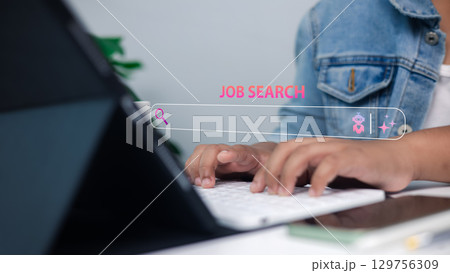 Person searching for jobs online using a computer with digital JOB SEARCH text overlay, representing online recruitment, career development, remote work, and modern employment technology. 129756309