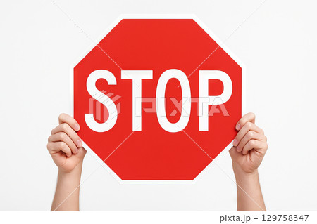 Hands holding a red stop sign isolated on white background. concept of traffic control, road safety, stop sign icon, warning signal, caution message. Hands holding a red stop sign isolated on white background. concept of traffic control, road safety, stop sign icon, warning signal, caution message. 129758347