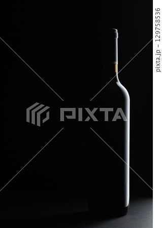 Red wine bottle silhouette over black background. 129758536