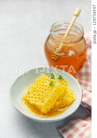 Honey, honeycomb and bee pollen creating delicious golden composition 129758547