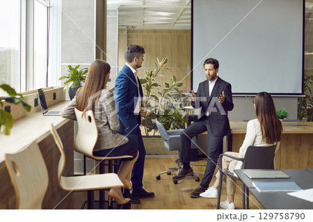 Business team discussing something during a corporate work meeting in the office 129758790