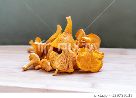Vibrant yellow chanterelle mushrooms arranged artistically on wooden surface, showcasing their unique shapes and textures, culinary or nature themed projects, Cantharellus cibarius, girolle Vibrant yellow chanterelle mushrooms arranged artistically on wooden surface, showcasing their unique shapes and textures, culinary or nature themed projects, Cantharellus cibarius, girolle 129759135