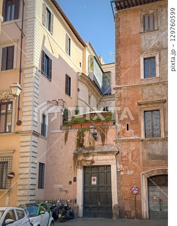 Historic buildings, with different architectural styles and colors, frame a narrow street in Rome, Italy 129760599
