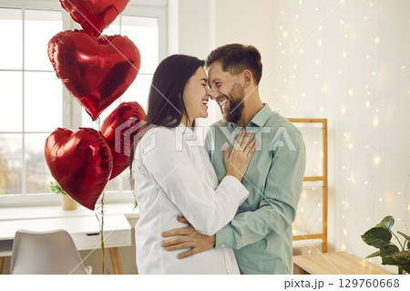 Happy, joyful couple in love having fun on a romantic Valentine's Day date at home 129760668