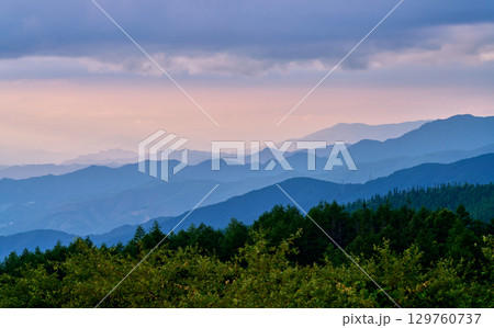 空と青く重なる山の稜線 129760737