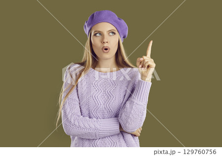 Portrait of young woman with raised index finger Portrait of young woman with raised index finger 129760756