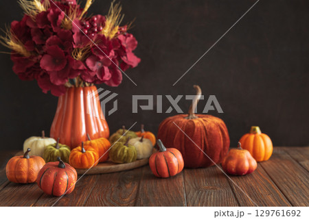 Autumnal composition of decorative mini pumpkins on a wooden surface. Autumnal composition of decorative mini pumpkins on a wooden surface. 129761692