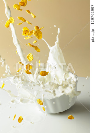 Dry honey cornflakes with milk splashes in a ceramic plate. Dry honey cornflakes with milk splashes in a ceramic plate. 129761997