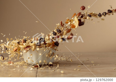 Muesli in motion on a beige background. 129762000