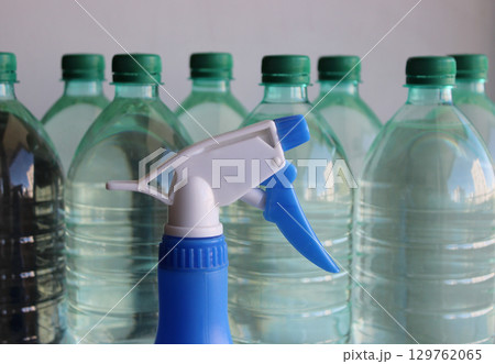 Plastic Flower Sprayer In Front Of Full Water Bottles In A Row 129762065