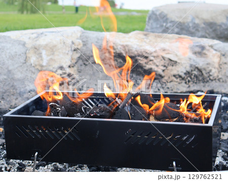 Outdoor Barbecue Grill With Burning Flames in a Natural Setting 129762521
