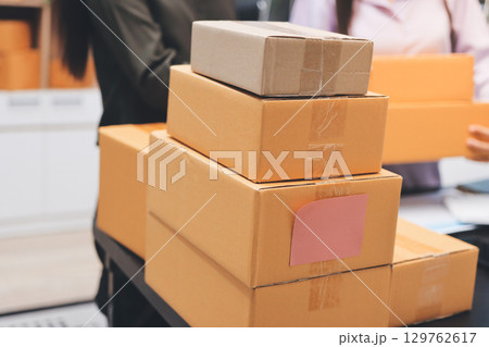 Portrait of Starting small businesses SME owners, two Asian woman check online orders Selling products working with boxs freelance work at home office, sme business online small medium enterprise 129762617