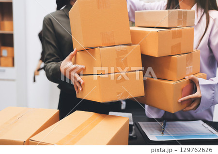 Portrait of Starting small businesses SME owners, two Asian woman check online orders Selling products working with boxs freelance work at home office, sme business online small medium enterprise 129762626