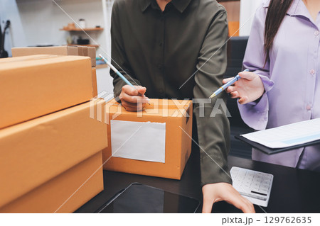 Portrait of Starting small businesses SME owners, two Asian woman check online orders Selling products working with boxs freelance work at home office, sme business online small medium enterprise Portrait of Starting small businesses SME owners, two Asian woman check online orders Selling products working with boxs freelance work at home office, sme business online small medium enterprise 129762635