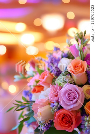 Floral arrangement featuring roses, carnations and other blossoms with bokeh background. 129763522
