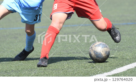 ドリブルするサッカー選手 129764020