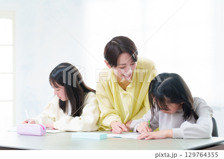 勉強をする女の子　勉強を教えるお母さん 129764355