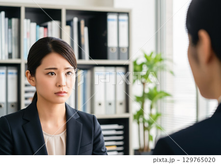 同僚の相談を真剣な表情で聞くビジネスウーマン 129765020