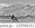 asian man sitting in a chair looking at a mountain 129766231