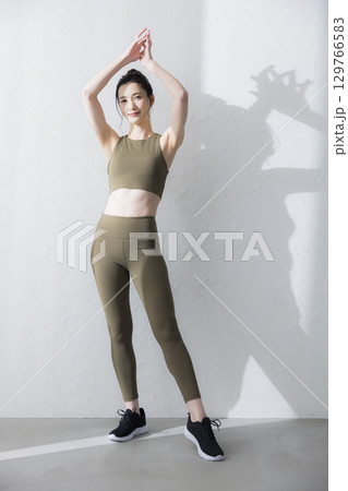 トレーニングウェアでストレッチをする女性 トレーニングウェアでストレッチをする女性 129766583